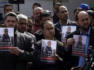 Turkish journalists stand with posters of Yasser Mortaja who was shot dead by the Israeli army while covering the Great March of Return protest in Gaza. (AFP/ File Photo) 