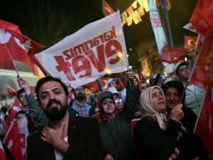 Supporters of Turkish President Erdogan wave Turkish national flags and flags reading "yes" as they celebrate during a rally on April 16, 2017 in Istanbul after the results of a nationwide referendum. (AFP/Ozan Kose)