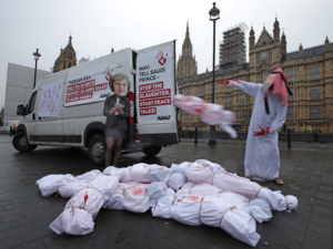 Demonstrators wearing masks depicting Britain's Prime Minister Theresa May (L) and Saudi Arabia's Crown Prince Mohammed bin Salman protest outside of the Houses of Parliament in London on March 7, 2018, against the visit to the U.K. by the Crown Prince. (Daniel Leal-Olivas / AFP) 