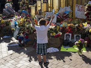 A boy raises his arms in the air in front of a memorial at the Muhammad Ali Center on June 10, 2016 in Louisville, Kentucky.  (AFP/Ty Wright)