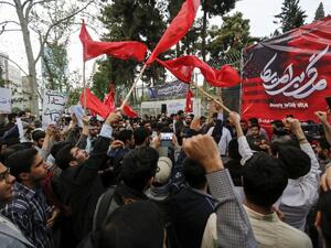 Iranians chant slogans and wave red flags defaced with the "Down with USA" slogan during an anti-US protest outside the former US embassy headquarters in Tehran, May 9, 2018. Iranians reacted with sadness, resignation and defiance  to U.S. President Donald Trump's withdrawal from the nuclear deal. ATTA KENARE/AFP