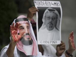 A demonstrator dressed as Saudi Crown Prince Mohammed bin Salman with blood on his hands protests with others outside the Saudi Embassy in Washington, DC. (AFP/File)