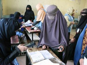 An Afghan Independent Election Commission (IEC) official scans a voter with a biometric device at a polling centre for the country's legislative election in Kandahar province on October 27,2018. (JAWED TANVEER / AFP)