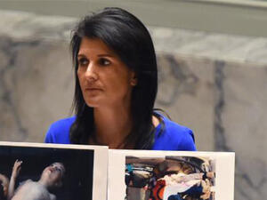 US Ambassador to the UN, Nikki Haley holds photos of victims as she speaks as the UN Security Council. (AFP)