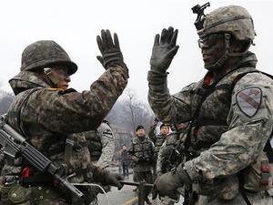 Soldiers from South Korea (L) and the US (R) gesture as they set up a floating bridge during a US-South Korea joint river crossing exercise. (AFP/ File Photo)