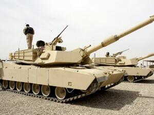 Iraqi soldier stands atop a tank during a training session with US troops on using US-made tanks at joint military base (AFP)