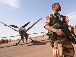 A French soldier of the aerial detachment of the Operation Barkhane stands guard near a Reaper drone at the Nigerian military airport Diori Hamani in Niamey. (AFP)