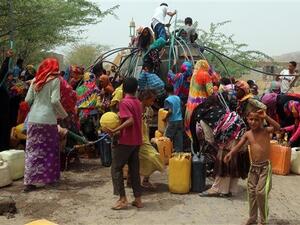 Yemenis gather next to a water tank to collect water in an impoverished coastal village on the outskirts of the Yemeni port city of Hudaydah, on May 12, 2018. (AFP)