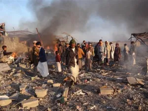 Smoke rises as Yemenis inspect the damage at the site of Saudi-led airstrikes in the northwestern city of Sa’ada, Yemen