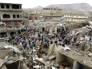 Vendors hunt for goods from under the rubble of their shops following an air strike by the Saudi-led coalition on the Yemeni capital Sanaa on 20 July 2015 (AFP/Mohammed Huwais)