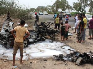 Aden residents examine the charred remains of a car bomb in Aden on July, 15. (AFP/Saleh al-Obeidi)