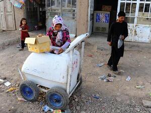 An eight-year-old Afghan girl stocks her ice cream cart. She is one of thousands of Afghan children providing for their families. (AFP/File)