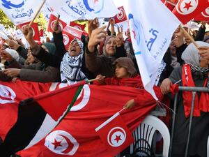 Tunisians wave their national flag and the flag of the Ennahda Islamist party. (AFP/ File)