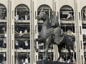 Iraqi King Faisal rides his horse outside government buildings in Baghdad, damaged in a 2009 suicide bombing.  (AFP/Ahmad al-Rubaye)