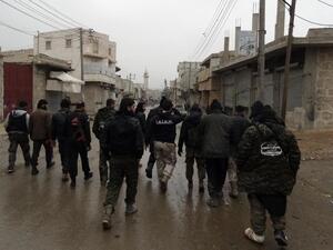 Opposition fighters from the Ahrar Al-Sham brigade walk in Aleppo during ongoing clashes with government forces on Jan. 27, 2014. (AFP/Baraa al-Halabi)