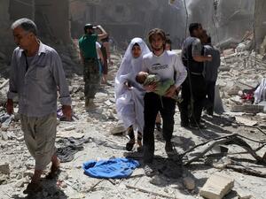A Syrian family walks amid the rubble of destroyed buildings following a reported airstrike on April 28, 2016 in the Bustan al-Qasr rebel-held district of the northern Syrian city of Aleppo. (AFP/Baraa al-Halabi)