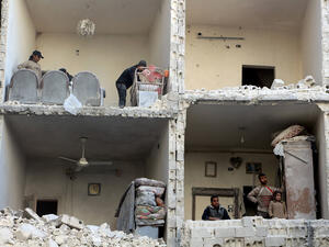 Civilians examine the bombed-out remains of a house in Aleppo, Syria following airstrikes in December 2015.  (AFP/Karam al-Masri)