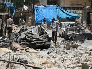 Syrian men look at the damage on June 13, 2016, following reported air strikes the previous night on the rebel-held neighborhood of al-Mashhad in the northern city of Aleppo. (AFP/Ameer al-Halbi)