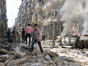 People walk amid the rubble of destroyed buildings following a reported air strike on the rebel-held neighborhood of al-Kalasa in the northern Syrian city of Aleppo, on April 28, 2016. (AFP/Ameer al-Halbi)
