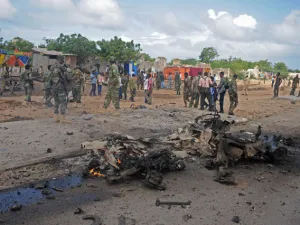 Soldiers patrol around the wreckage of a suicide car bomber that smashed into a pickup truck carrying security officers in Mogadishu. (AFP/File)