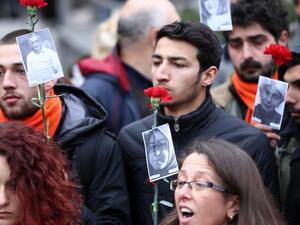 Demonstrators hold carnations and pictures of victims of Sunday's suicide bomb attack during a silent march to pay tributes to the victims, in Ankara, on March 15, 2016 in Ankara. (AFP/Adem Altan)
