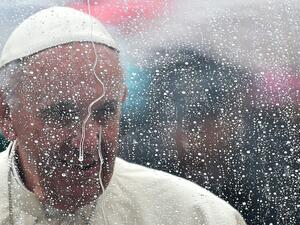  زعيم الفاتيكان فرنسيس خلف زجاج كساه المطر 