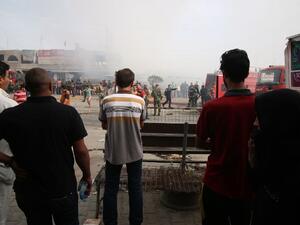 Iraqi passersby stand at the site of a suicide bombing in the Baghdad Jadida area on April 25, 2016. The blast ripped through shops in eastern Baghdad, killing at least seven people. (AFP/Haidar Mohammed Ali)