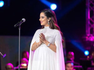 ارتدت بلقيس فستاناً ناعماً باللون الأبيض منسدلاً بنعومة بطول جسمها 