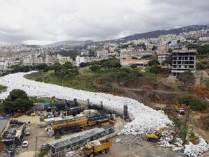 Trucks are seen next to piles of garbage in Jdeideh, a Beirut suburb, ahead of moving it to the country's largest landfill of Naameh, just south of the Lebanese capital, on March 20, 2016. (AFP/Anwar Amro)