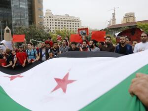 Syrian and Lebanese protesters wave the Syrian flag as they take part in a demonstration in front of United Nations offices in Beirut in solidarity with the civilians of Aleppo on May 1, 2016. (AFP/Anwar Amro)