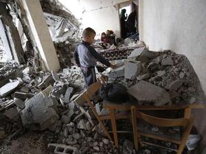 Palestinian boy searches for toys amidst the rubble of his home. (AFP/File)