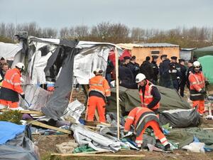 Workers demolish the Calais refugee camp in France earlier this year, as police look on. (AFP/File)