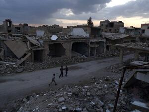 Syrian children walk past heavily damaged buildings in the rebel-held town of Douma, on the eastern edges of the capital Damascus on February 27, 2016. (AFP/Sameer al-Doumy)