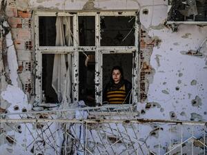 A woman looks through a window of her ruined house on March 8, 2016 during International Women`s day in Cizre district. (AFP/Ilyas Akengin)