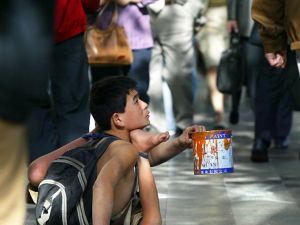 Beggar begs for alms from passersby along a street (AFP/File Photo)	
