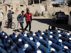 A member of the Qatari Red Crescent delivers aid, in the form of diesel fuel, to families in need in the rebel-held town of Beit Sawa, on the outskirts of the capital Damascus on March 7, 2016. (AFP/Amer al-Mohibany)