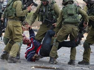 Israeli soldiers detain a Palestinian stone thrower near Beit El, on the outskirts of the West Bank city of Ramallah, on October 7, 2015. (AFP/Abbas Momani)
