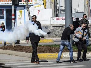 People react as a tear gas canister is thrown by Turkish police during clashes in central Diyarbakir on March 17, 2016. (AFP/Ilyas Akengin)