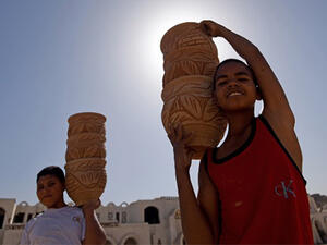 Egyptian boys carry clay pots at a workshop in the old city of the capital Cairo. (AFP/File)