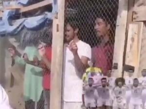 The Emirati man is seated outside a bird cage containing migrant workers inside [Twitter]