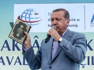 Turkey's President Recep Tayyip Erdogan holds a Koran as he speaks during an opening ceremony at the Selehaddin Eyyubi airport on May 26, 2015, in eastern city of Hakkari. (AFP/STR)