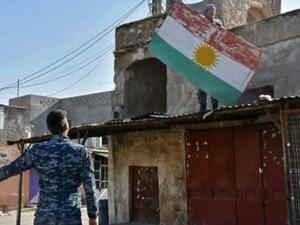 An Iraqi fighter loyal to Baghdad removes a Kurdish flag from a building in the Altun Kupri region of Kirkuk province on October 20, 2017. (AFP/File)