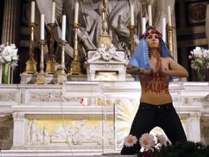 A Femen activist makes a protest at a French church in 2013 (AFP / File)
