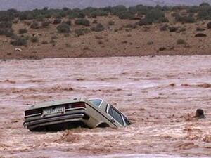 A man is separated from his car as flash floods sweep the vehicle from a road in Ouarzazate, southern Morocco. (AFP/File)