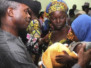 One of the 21 freed Chibok girls cries while holding her baby as Nigerian Vice President Yemi Osinbajo looks on at his office in Abuja on October 13, 2016. (AFP/Philip Ojisua)