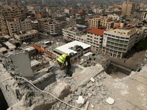 A Palestinian worker removes debris from buildings which were destroyed during the 50-day war between Israel and Hamas militants in the summer of 2014, in Gaza City, on April 5, 2016. (AFP/Mohammed Abed)