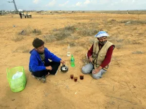 مزارع فلسطيني يحتسي الشاي مع ابنه خلال استراحة من العمل في الارض/أ.ف.ب