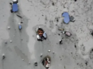 فلسطيني ينظر من خلال الحفر التي احدثتها غارة جوية اسرائيلية في جدران منزله في مخيم جباليا للاجئين الفلسطينيين في غزة/أ.ف.ب