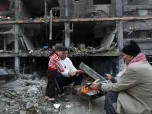 فلسطينيون بالقرب من منزل مدمر في الحرب الاخيرة/أ.ف.ب