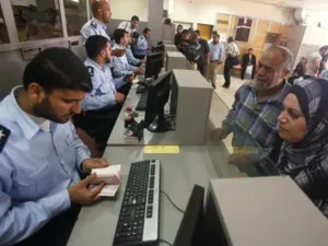 شرطي من حماس يفحص جواز سفر مسافر فلسطيني عند معبر رفح في جنوب قطاع غزة 
